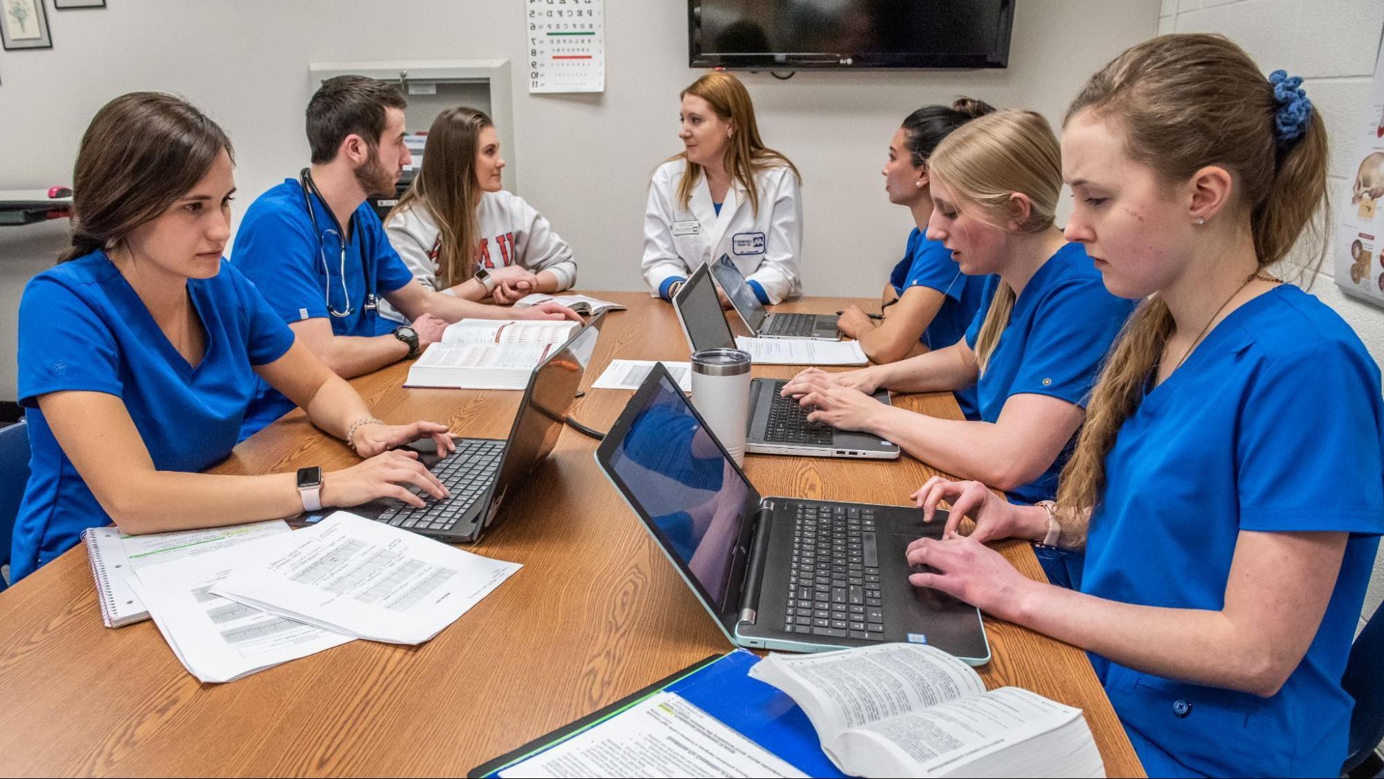 Group of nurses studying in their scrubs.